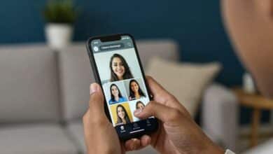 Pessoa segurando um celular transmitindo uma live em ambiente descontraído, com elementos de interação digital aparecendo na tela