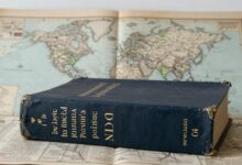 Livros antigos, dicionários e mapas ilustrando a evolução da língua portuguesa ao longo do tempo