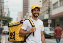 Um entregador da 99 Food sorrindo, segurando uma mochila de entrega térmica em uma rua movimentada da cidade, com o logotipo da 99 Food visível.
