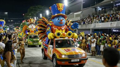 Um desfile vibrante de uma escola de samba no Sambódromo, com carros alegóricos grandiosos, passistas fantasiados e uma multidão animada.