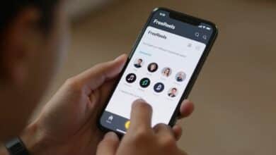 Close-up de uma pessoa sorrindo enquanto edita um vídeo curto em seu smartphone, com a interface do aplicativo FreeReels visível, mostrando ícones de música e efeitos especiais.