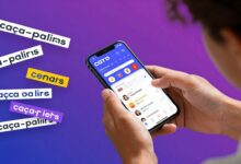 Uma pessoa sorrindo enquanto joga um jogo de caça-palavras em seu smartphone, com letras e palavras flutuando ao redor da tela em um design moderno e colorido.