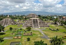 Uma visão panorâmica da grandiosa cidade asteca de Tenochtitlán, com suas pirâmides imponentes, canais e jardins flutuantes (chinampas) sob um céu dramático.