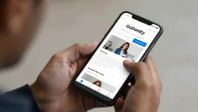 Pessoa utilizando o app da GoDaddy no celular para criar um site facilmente