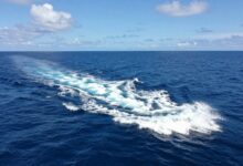 Uma vista aérea deslumbrante de um oceano azul profundo com ondas espumantes, representando a vasta e misteriosa natureza dos mares.