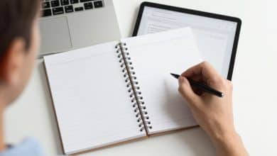 Pessoa organizando tarefas, notas digitais e compromissos em um ambiente moderno com o OneNote aberto em um computador