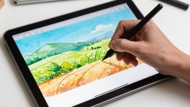 Ilustração digital sendo criada no Sketchbook em um tablet com caneta stylus, mostrando pincéis, camadas e um desenho colorido em andamento.